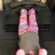 An adult with cerebral palsy performs sit-ups with weights across her legs.